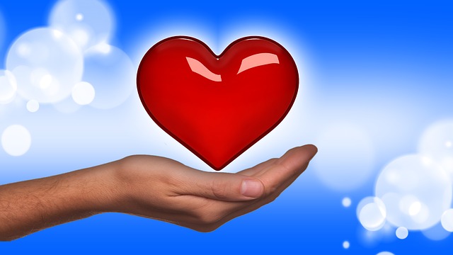 День святого Валентина - рука на которой находится красное сердце на фоне голубого неба